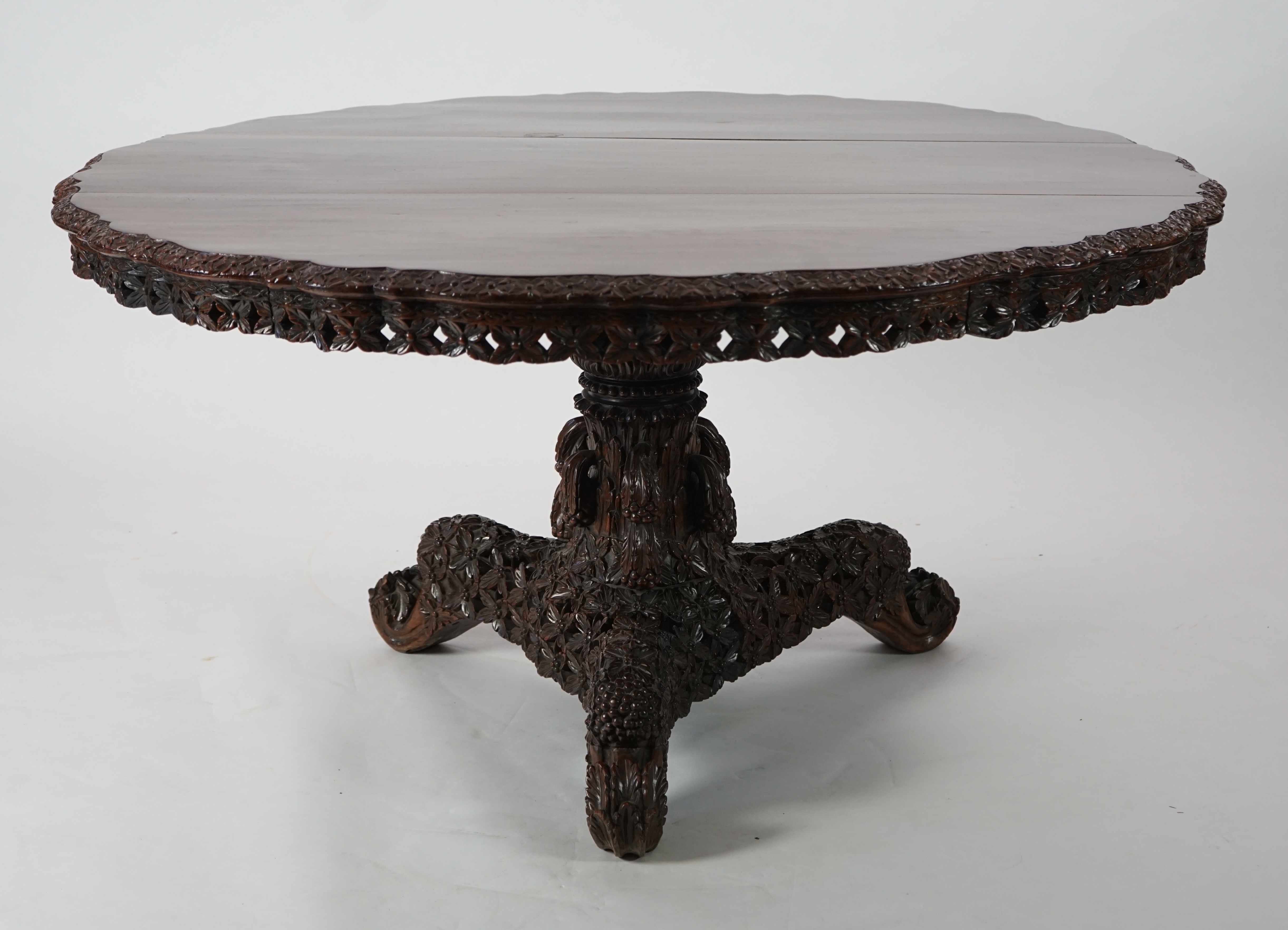 A 19th century Anglo-Indian hardwood foliate carved tilt top centre table